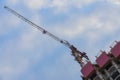 Specially diagonal image of construction tower crane next to building under construction against the background of the Royalty Free Stock Photo