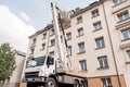 specially equipped truck with crane is replacing old and rusty downpipes on residential building