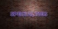 SPECIALTIES - fluorescent Neon tube Sign on brickwork - Front view - 3D rendered royalty free stock picture