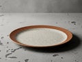 Speckled stoneware dinner plate with brown rim on concrete surface Royalty Free Stock Photo