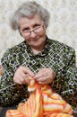 Spectacled grandmother binds cardigan Royalty Free Stock Photo