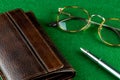 Leather Wallet Fountain Pen and Spectacles on a Felt Covered Table Royalty Free Stock Photo