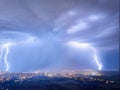 Spectacular, aerial shot of a city hit by multiple lightning. Royalty Free Stock Photo