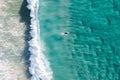 Spectacular aerial view of a surfer taking on waves in a blue ocean Royalty Free Stock Photo