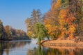 Spectacular autumn view of alley near pond in sunny day.