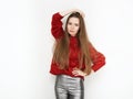 Spectacular blonde woman in red blouse silver leather pants posing in front of white wall. Graceful girl gorgeous long hair having