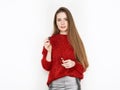 Spectacular blonde woman in red blouse silver leather pants posing with lip glow balm in front of white wall. Graceful girl gorgeo Royalty Free Stock Photo