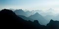 Spectacular blue and cyan mountain ranges silhouettes. Summit crosses visible.