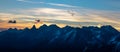 Spectacular blue mountain range silhouettes and sunrise with orange clouds