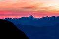 Spectacular blue mountain ranges silhouettes and pink violet clouds