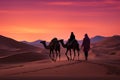 Spectacular desert sunset landscape with camels, sand dunes, and pink skies over the horizon at dusk Royalty Free Stock Photo