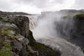 Spectacular Dettifoss waterfall in Iceland after floods filled with muddy water and tourists in raincoats Royalty Free Stock Photo