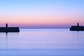 Spectacular early morning view of West and East Pier lighthouses of famous Dun Laoghaire harbor during the blue hour