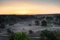 Spectacular sunrise with rays of sun over the blooming purple heather with thin layers of fog.