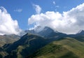 Spectacular green mountain landscape in Kazbegi, Georgia, on sunny day with snow mountain peaks covered by clouds