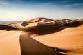 Spectacular large sand dunes of the Erg Chebbi desert in Morocco. Tall sand dunes with wind blowing sand over the top