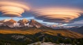 Spectacular lenticular clouds hovering over majestic mountain peaks at sunset Royalty Free Stock Photo