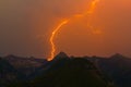 Spectacular lightning bolt strike in mountain peak silhouette, o