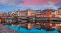 Spectacular medieval arched St Trinity bridge Ponte Santa Trinita over Arno river. Colorful spring sunset in Florence, Italy,