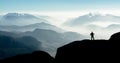 Spectacular mountain ranges silhouettes. Man reaching summit enjoying freedom.