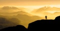 Spectacular mountain ranges silhouettes. Man reaching summit enjoying freedom. Sunrise with orange light. Royalty Free Stock Photo