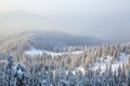 Spectacular panorama is opened on mountains, trees covered with white snow, lawn and blue sky with clouds. Royalty Free Stock Photo