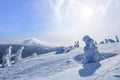 Spectacular panorama is opened on mountains, trees covered with white snow, lawn and blue sky with clouds. Winter landscape. Royalty Free Stock Photo