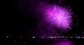 Purple colored fireworks exploding in to the night sky over the bay