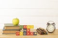 Spectacular representation of back to school with wooden cubes on a wooden table, books, green apple, old metal alarm clock and ru Royalty Free Stock Photo