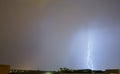Spectacular storm and lightning illuminates the sky and strikes one of the buildings in a city. Royalty Free Stock Photo