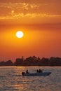 Boat with tourists at a summer sunset in the Danube Delta, Romania