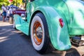 Spectacular turquoise shiny vintage retro car with a convex semicircular fender at a provincial street exhibition Royalty Free Stock Photo