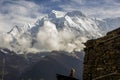 Spectacular view of Mount Annapurna II with a Nepali man in the foreground and a typical house during the Annapurnas round trek Royalty Free Stock Photo