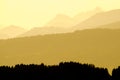 Spectacular view of mountain silhouettes. Yellow sunlight in early morning.