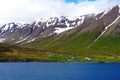 The spectacular view of the partially covered snowy mountain along the fjord near Olafsfjordur, Iceland