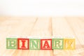 Spectacular wooden cubes with the word BINARY on a wooden surface.