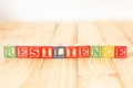 Spectacular wooden cubes with the word RESILIENCE on a wooden surface Royalty Free Stock Photo