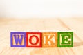 Spectacular wooden cubes with the word WOKE on a wooden surface