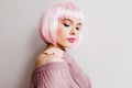 Spectacular young lady in stylish periwig standing with eyes closed. Pretty white girl wears pink wig posing in soft