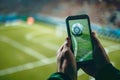 Spectator capturing the live football match through a smartphone camera at the stadium Royalty Free Stock Photo