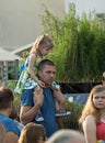 Spectator with girl on shoulders watch a show