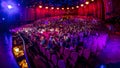 Spectators gather in the auditorium and watch the show in theatre timelapse. Large hall with red armchairs seats