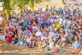 Spectators at a lecture on the open area of the beach.