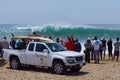Spectators and lifeguards observing huge surf
