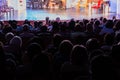 Spectators at a theater performance, in a cinema or at a concert. Shooting from behind. The audience in the hall