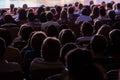 Spectators at a theater performance, in a cinema or at a concert. Shooting from behind. The audience in the hall