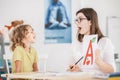 Speech therapist working with a child on a correct pronunciation Royalty Free Stock Photo