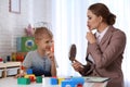 Speech therapist working with boy in office Royalty Free Stock Photo
