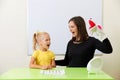 Speech therapist working with little girl in office training pronunciation Royalty Free Stock Photo