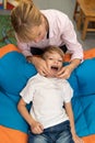 Speech therapy tongue massage to a child little boy with a logopedic probe. Professional female physiotherapist working Royalty Free Stock Photo